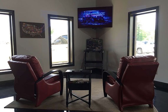 Indoor view of GT Collision & Accessories facility showing visitor area with chairs